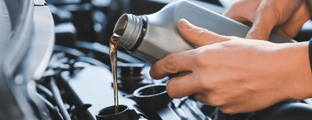 two hands holding engine oil and pouring it out